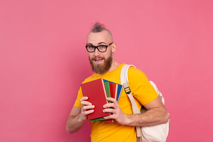 智能一个留着胡子 背着书包 拿着书 穿着休闲装 快乐的成人学生休闲保持爱好