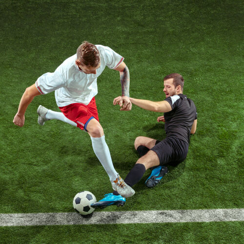 运动员足球运动员在绿草墙上抢断球职业男子足球运动员在体育场运动适合在比赛中跳跃 跳跃 移动的男子采取动作跳跃