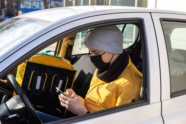 手套车上一个戴着黑色医用口罩的男人在打电话 背包在座位上在线男士包装