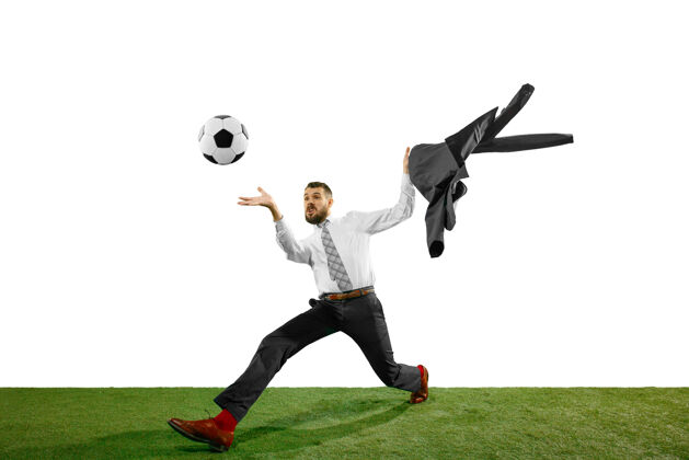 运动一个年轻的商人在白色场地上踢足球的全长镜头比赛积极比赛