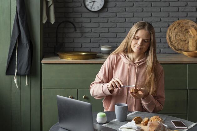 水平中等身材的女人在准备早餐在家放松笔记本电脑