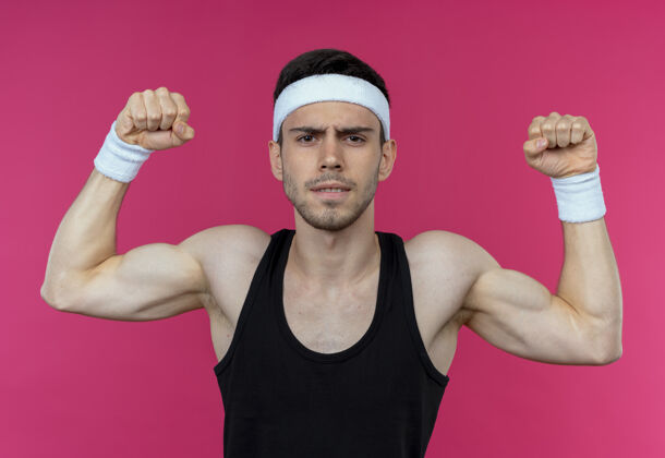 站戴着头巾的年轻运动型男子 看起来紧张地举起拳头 摆出一副粉色的运动装年轻粉红姿势