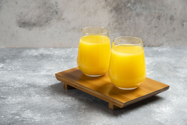 维生素木板上放两杯鲜橙汁凉爽黄色柑橘