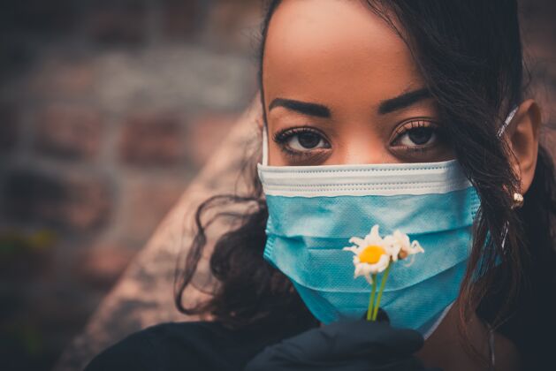 肖像戴着医用口罩的美丽的黑人女孩手套流行年轻