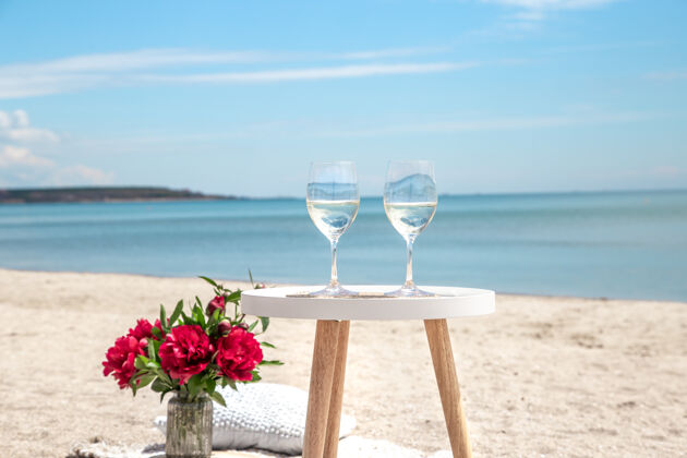 香槟带着鲜花和香槟在海边野餐度假的概念大海夏天花