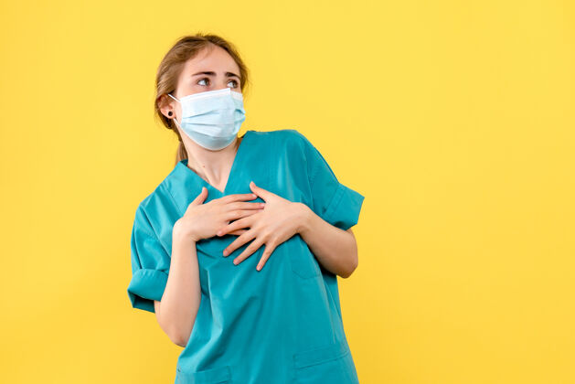 肖像正面图黄色背景上戴口罩的女医生医院健康危机-大流行面具医疗成人