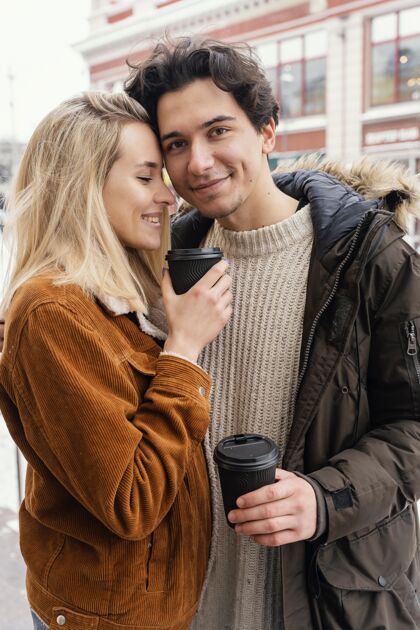男人年轻夫妇在户外享受一杯咖啡休闲情人拥抱