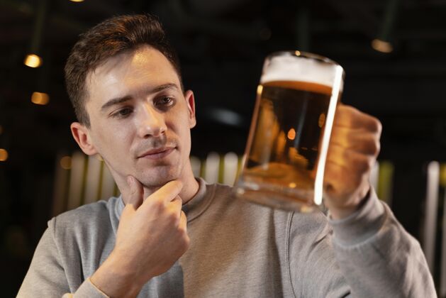 饮料特写拿着啤酒杯的男人酒吧享受室内