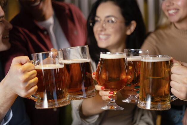 酒吧近距离微笑的朋友与啤酒杯水平饮料朋友