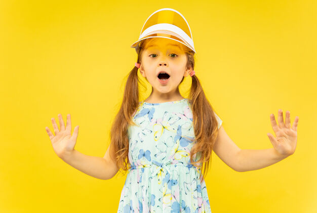 帽子美丽动情的黄色小女孩童年表情欢呼
