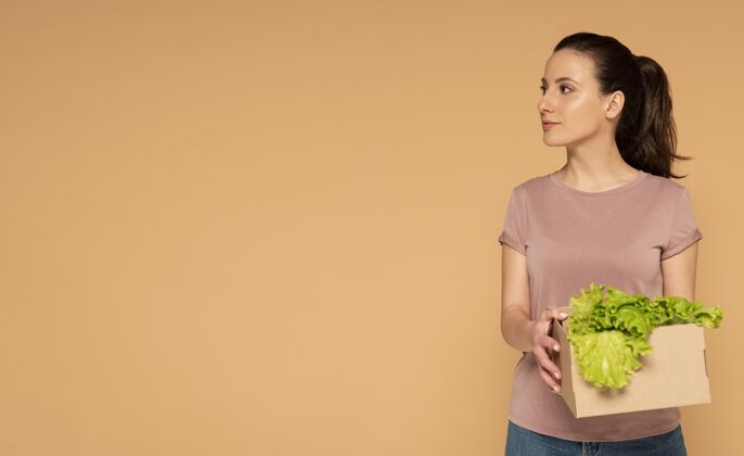 复制空间一个穿着休闲服的女人 手里拿着可重复使用的卡通蔬菜盒莴苣零浪费回收