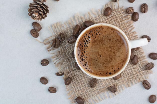 新鲜的咖啡杯和咖啡豆在麻布上高质量的照片芳香豆类饮料