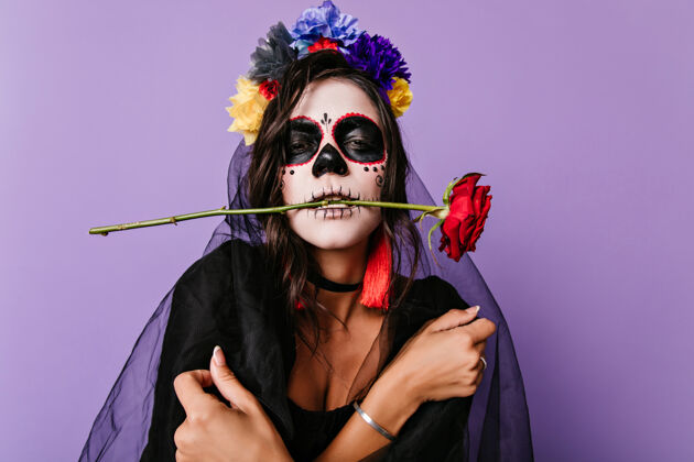 噩梦悲伤的死新娘在万圣节摆出黑色面纱沮丧的墨西哥脸画的女人站在紫色的墙上墨西哥墨西哥面具