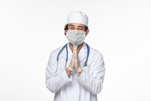 听诊器正面图男医生穿着医疗服 戴着无菌口罩 以防白墙病毒冠状病毒大流行疾病男性疾病医生