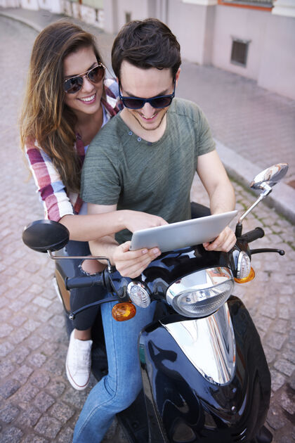 太阳镜一对夫妇在城里骑摩托车谈话看交通