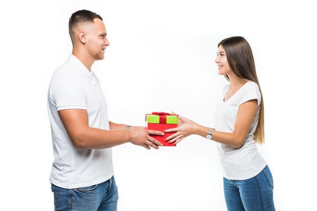 树漂亮的年轻夫妇带着红色的礼物盒 惊喜地隔离在白色上给予男朋友丈夫