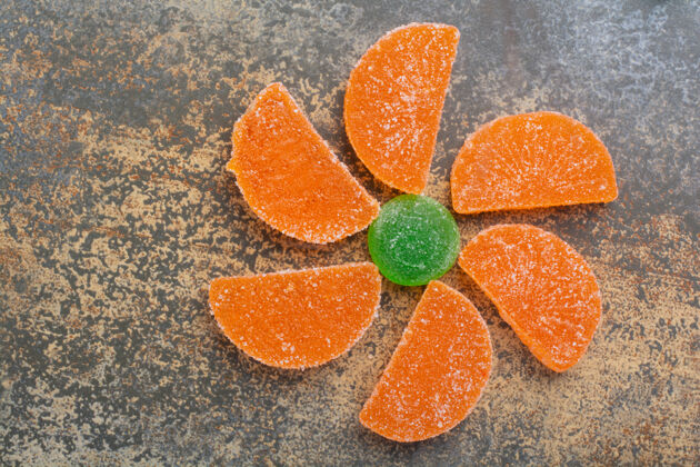 绿色甜美的彩色果冻糖大理石背景食物橙色果酱