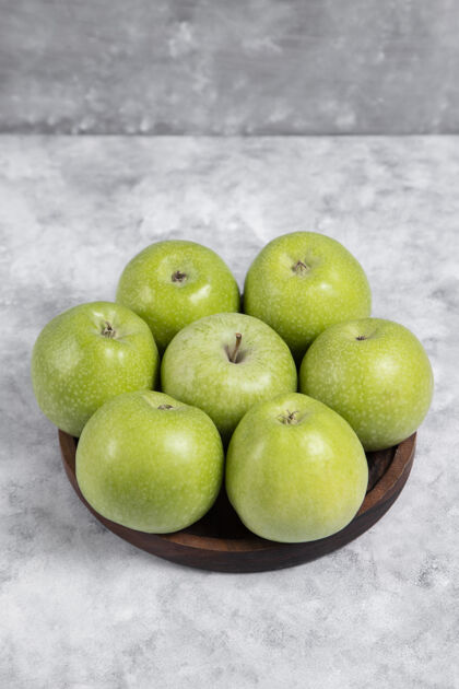 美味石头上放着一碗新鲜的绿色甜苹果光泽成熟叶子