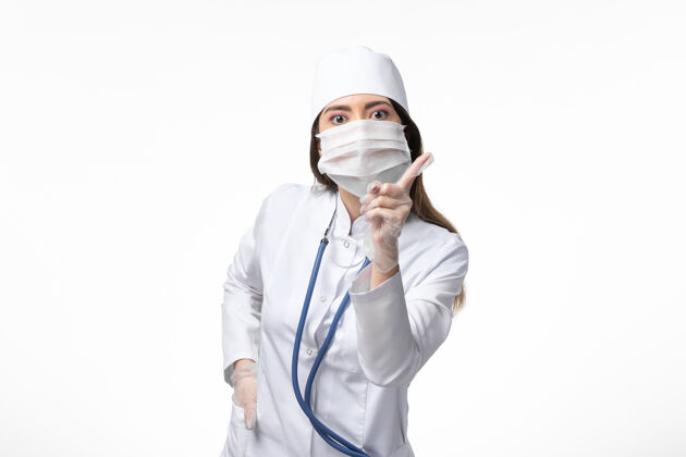 女性正面图女医生身穿白色无菌医疗服 带口罩 因白墙上冠状病毒病冠状病毒-大流行性疾病病毒冠状病毒外套面具