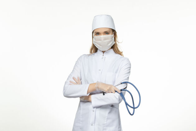 办公桌前视女医生穿着医疗服戴防护口罩因白色办公桌上冠状病毒病冠状病毒-大流行病毒病工作人员工人