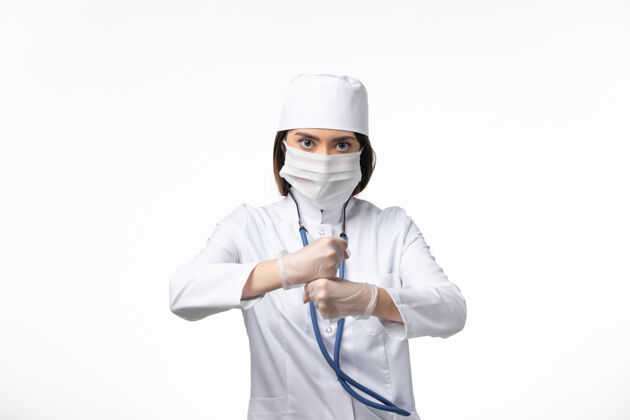 药品正面图女医生穿着白色医疗服 戴着口罩 因冠状病毒在白墙上传播疾病 医学病毒大流行大流行到期冠状病毒