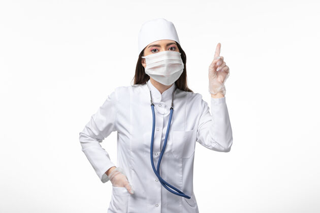 疾病正面图女医生穿着白色无菌医疗服 带着口罩 由于白色办公桌上有冠状病毒疾病冠状病毒-大流行性疾病病毒女性医学冠状病毒