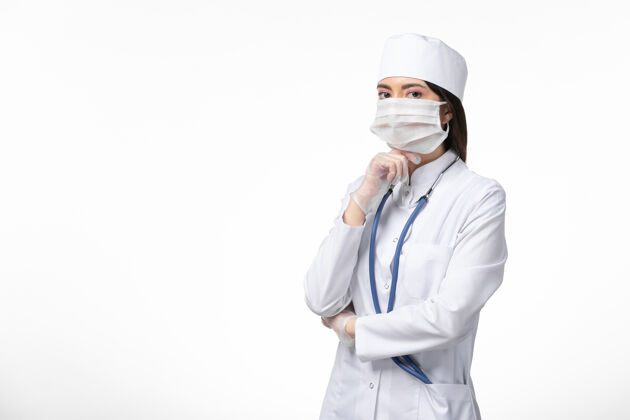 医生正面图女医生穿着白色医疗服 戴着口罩因冠状病毒思考白墙健康病大流行人医学观点