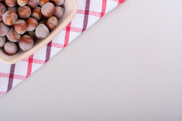 背景粉红色的有机榛子壳碗放在白色背景上高品质的照片榛子健康天然