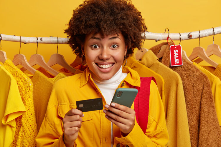 美国漂亮的非洲女人验证银行账户 通过智能手机在线支付 持有信用卡手机手机标签
