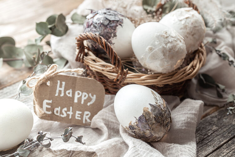 组成漂亮的复活节彩蛋放在一个用干花装饰的篮子里复活节快乐静物传统铭文