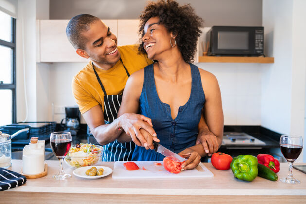 庆祝一对年轻的拉丁夫妇在家里的厨房一起做饭的肖像关系 厨师和生活方式的概念公寓欢呼厨房