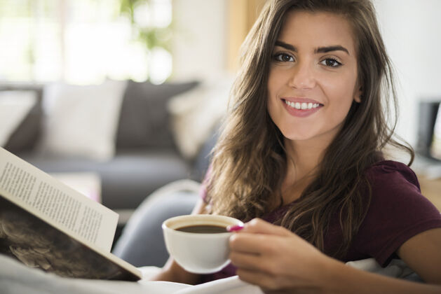 放松年轻女人看书喝咖啡深情微笑欢呼