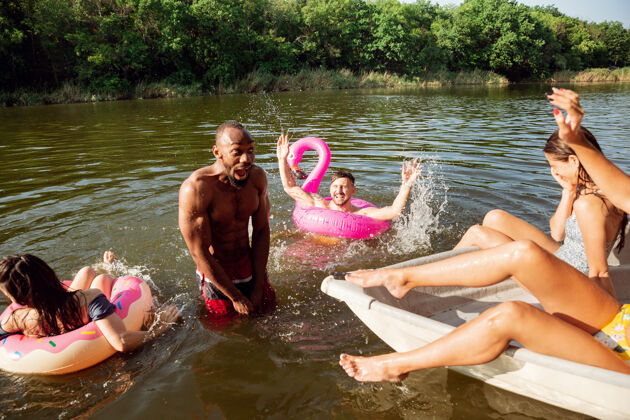 自然一群快乐的朋友在河里欢笑和游泳河流海滩冒险