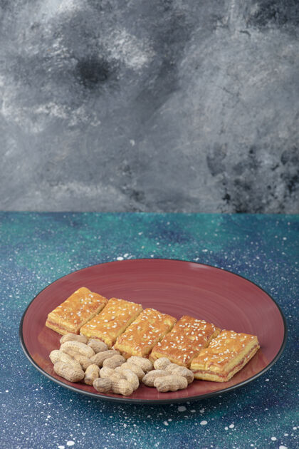 饼干一个红色的盘子 上面放着健康的坚果和美味的饼干饼干零食饼干