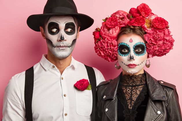 万圣节万圣节的面部艺术女人和男人站在一起在墨西哥服装家伙幽灵情侣