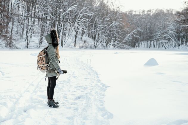 年轻人冬天背着背包的女人侧视图雪冬女人场景