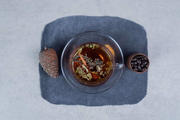 谷物一杯茶 松果和大理石背景上的谷物高品质的照片松果杯子草药