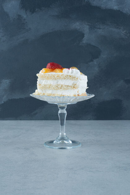 块美味的蛋糕放在大理石背景的玻璃板上蛋糕食品奶油