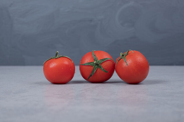 花园三个新鲜的西红柿在灰色背景上高质量的照片成熟的红色蔬菜