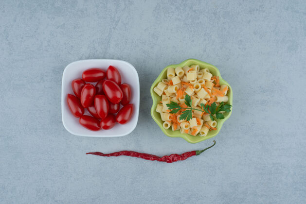 白色白盘子的番茄樱桃和绿盘子的美味通心粉高品质的照片绿色胡椒粉美味