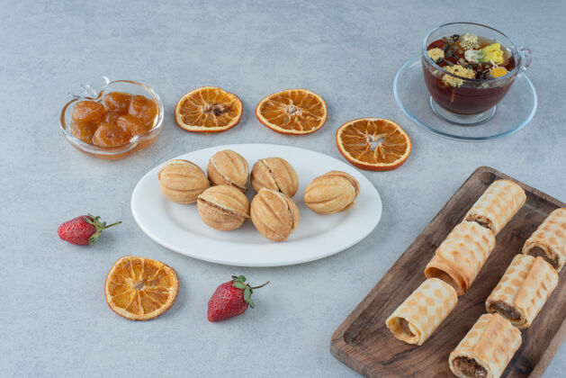 白甜甜的甜点配上橘子干和一杯凉茶 大理石背景高品质照片面包房板茶