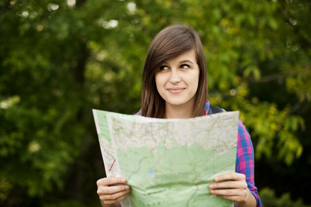 冒险拿着地图的年轻漂亮女人年轻人思考制图