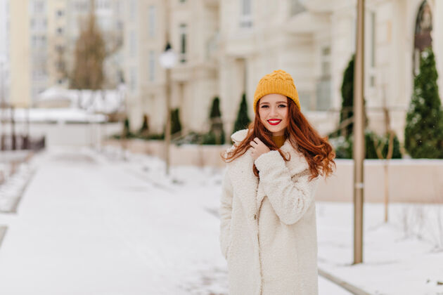灵感可爱的白人妇女在冬日摆姿势穿着长外套的满意的姜女士的户外照片休闲散步女性