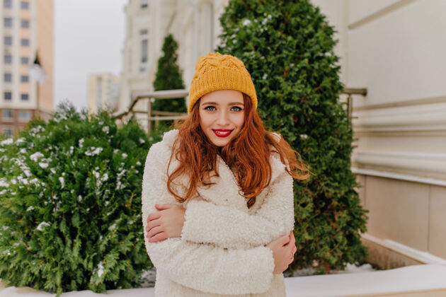 欧洲害羞的姜姑娘的冬天肖像欧洲女人戴帽子和外套的户外照片女孩冷冻服装