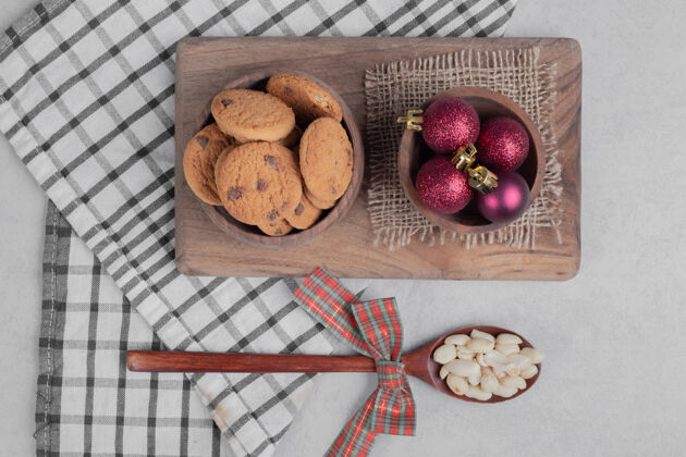 腰果一碗饼干和圣诞球放在白色的桌子上高质量的照片好吃球饼干