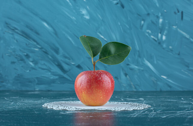 有机美味的苹果在doily上 在蓝色的背景上高质量的照片饮食天然甜
