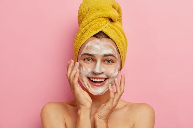 女士快乐白种女人特写肖像用香皂和水洗脸 要有健康的肤色 去除污垢和汗液皮脂 头上用黄色毛巾包好湿漉漉愉悦沐浴