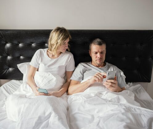 小玩意夫妻在床上用手机电话设备上瘾