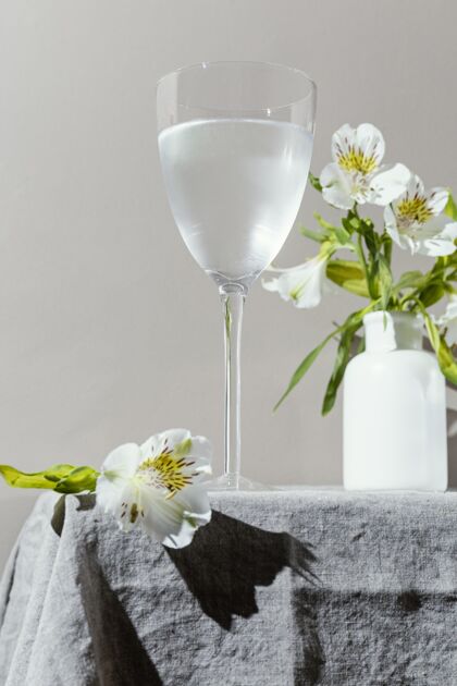 花桌上有一杯水和花一杯水饮料花瓶