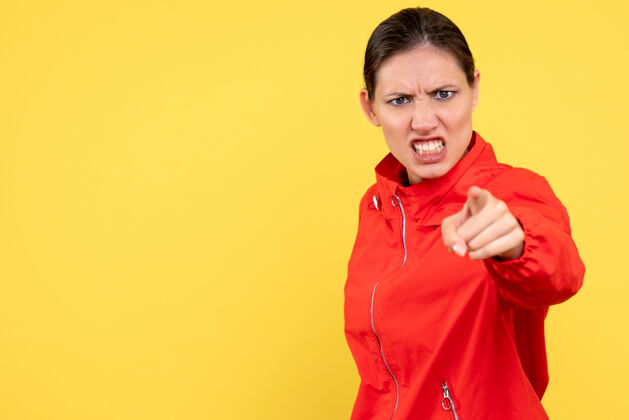 运动员正面图穿着红色外套的年轻女性在黄色背景上愤怒愤怒红人